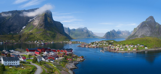 Wall Mural - Beautiful aerial panorama of  the blue sea surrounding the fishing village  and rocky peaks Reine, Moskenes, Lofoten, Norway, sunny arctic summer 