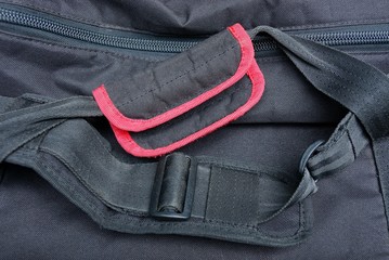 black red handles and harnesses made of cloth on a backpack