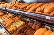 © LIGHTFIELD STUDIOS - selective focus of freshly baked various bread in pastry department of grocery store
