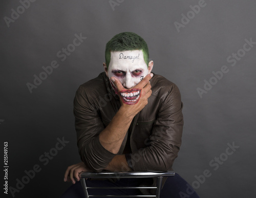 Photo  dark creepy joker face screaing angry. green hair