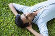 © RealityImages - Happy young man lying on the grass relaxing