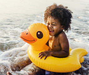 Wall Mural - Cute toddler with duck tube on the beach