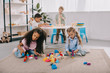 © LIGHTFIELD STUDIOS - focused multiracial preschoolers playing with wooden blocks in classroom