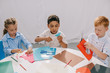 © LIGHTFIELD STUDIOS - focused multiracial kids making paper applique in classroom