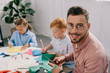 © LIGHTFIELD STUDIOS - selective focus of smiling teacher and preschoolers making paper applique in classroom