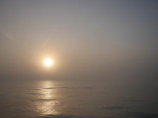 Wall Mural -  misty fog over sea with sun