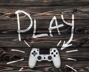 Sticker - white gamepad on a dark wooden background. word play and an arrow pointing to the gamepad.