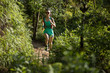 Determined woman trail runner running in morning forest