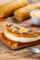 Wooden table with several ingredients for the preparation of Cachapas with cheese, corn, butter, ground corn and white cheese, Venezuelan Cuisine