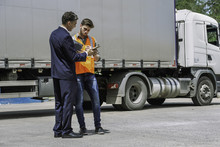 Worker And Businessman Discussing Near Lorry