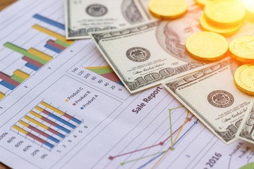 Banknote and coins depicted on economic graphs dollar currency, financial investment concepts that affect the global economy and people's spending, and saving money for future use for indissolubility.