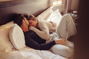 Loving couple sleeping together in bed