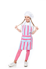 Wall Mural - schoolchild in costume of chef holding braids and looking at camera isolated on white