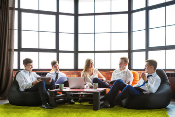 Group of business people sitting in an informal atmosphere.