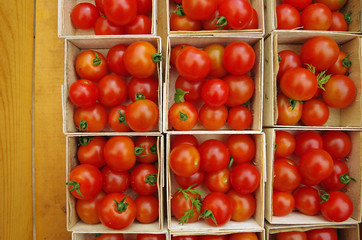 Wall Mural - Cherry tomatoes displayed in wooden baskets   on wood grain table viewed from above 