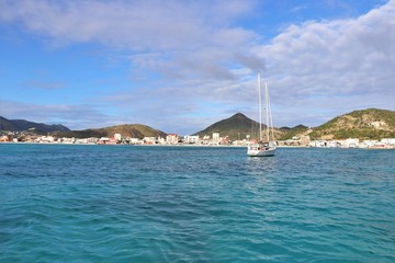 Wall Mural - Sailboat on the ocean with a tropical island in the background