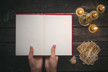 Wall Mural - Open book of magic with blank pages and tarot cards on fortune teller table background. Futune reading concept. Divination.