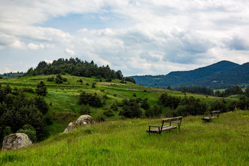 Calm scenery springtime view of very green landscape with two benches in Rhodope mountain near the village of Ravnogor in Pazardzik county, Bulgaria