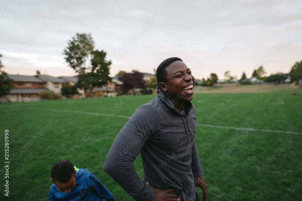 Man and boy enjoying each other and laughing in field