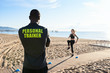 © guille Faingold/Stocksy - Personal trainer looking at exercising sportswoman on the beach.