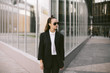 © Alexey Kuzma/Stocksy - Beautiful young woman with smartphone in tomboy style