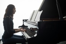 Schoolgirl Playing Piano In Music School
