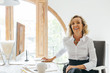 © Bonninstudio/Stocksy - Smiling mature businesswoman working at office.