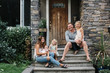© Rob and Julia Campbell/Stocksy - Family of five hanging together out on front porch steps in summ