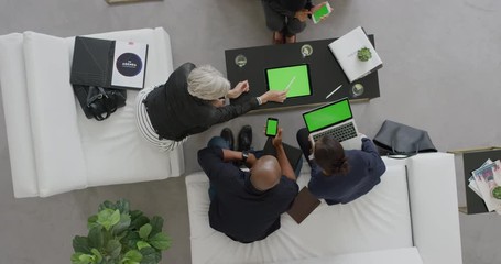 Wall Mural - professional business people brainstorming innovative ideas for startup company viewing green screen using mobile computer technology in office lobby meeting above view