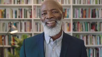 close up portrait of senior african american businessman with beard smiling confident enjoying successful career milestone professional mature black male wearing suit in library 