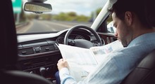 Businessman Reading Newspaper In A Car