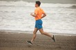 © Wavebreak Media - Man jogging on shore at beach
