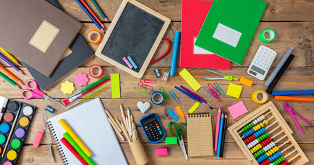 Back to school. School supplies on wooden background, top view