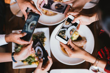 Group Of Friends Going Out And Taking A Photo Of Italian Food Together With Mobile Phone.