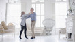 © icsnaps - Portrait of older mature couple in love dancing in their white apartment