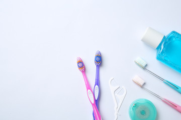 Flat lay composition with manual toothbrushes and oral hygiene products on white background