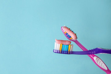 Toothbrushes with paste on color background, closeup