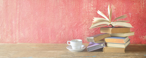 Wall Mural - Open Book on a pile of old books and a cup of coffee, panorama, good copy space