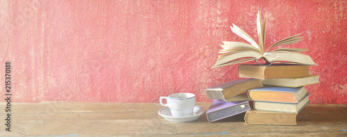 Fotografía Open Book on a pile of old books and a cup of coffee, panorama, good copy space