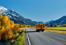 School Bus On Highway In Colorado At Autumn