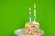 © driftwood - slice of birthday cake with candles on neon green background