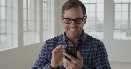 portrait of businessman entrepreneur using smartphone texting browsing sending messages on mobile phone technology business networking in office apartment