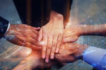 double exposure of hand of group of business people team joining hands together with modern city background, team leader, successful, support, partner, teamwork, confident and connection concept