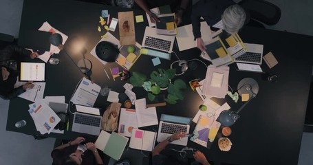 Wall Mural - multi ethnic business people working late planning strategy team manager sharing documents for corporate project developing creative ideas in messy boardroom top view