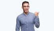 © Krakenimages.com - Handsome young elegant man wearing glasses smiling with happy face looking and pointing to the side with thumb up.