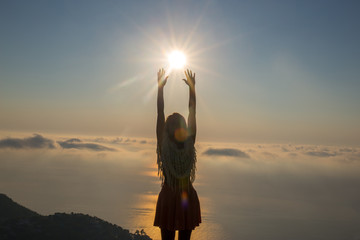 Beautiful woman reaching for the sun