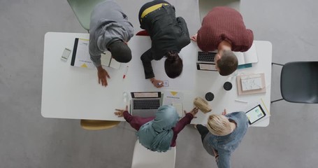 Wall Mural - diverse team of web developers brainstorming ideas for startup business website planning design layout in modern office workplace above view