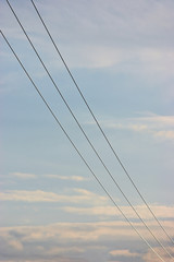 Summer evening sky background, vertical bright blue skyscape copy space, three power line cable wires, pink clouds cloudscape, 3 diagonal cables cloudy perspective, scenic twilight clouding pattern