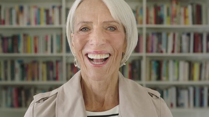 Portrait elderly woman student smiling bookshelf library university