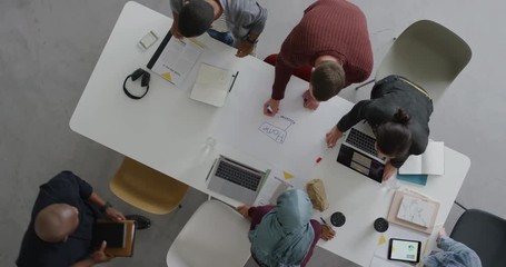 Wall Mural - multi ethnic team of web developers brainstorming ideas for startup business website planning design layout in modern office workplace top view